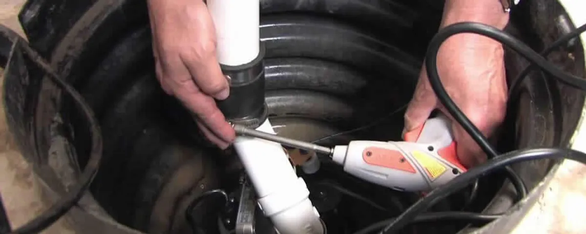 Sump pump installation technician connecting PVC discharge piping in Chandler, AZ