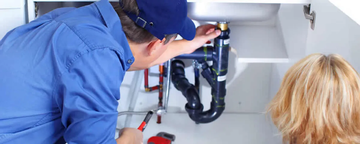 Plumber repairing under-sink drain pipes and fittings in Chandler, AZ